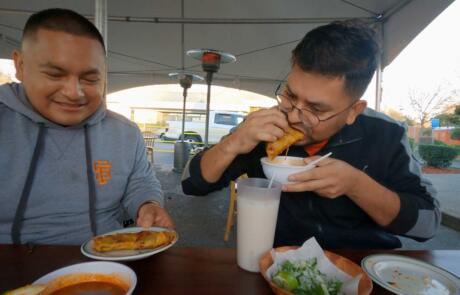 Uriel Brena and Neil Pacheco Eating QuesaBirria Tacos